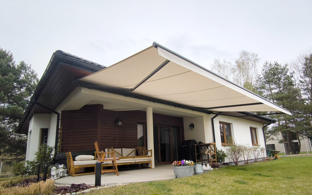 Markiza tarasowa Solaro z aluminiowymi ramionami zamontowana na tarasie domu jednorodzinnego