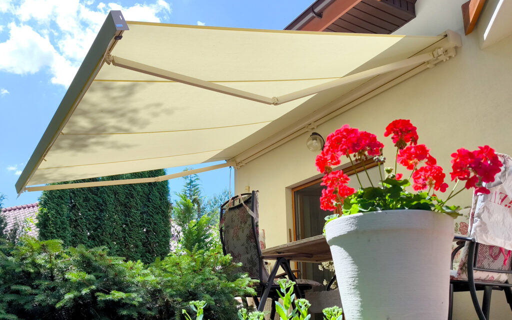 Markiza tarasowa Solaro z aluminiowymi ramionami zamontowana na tarasie domu jednorodzinnego