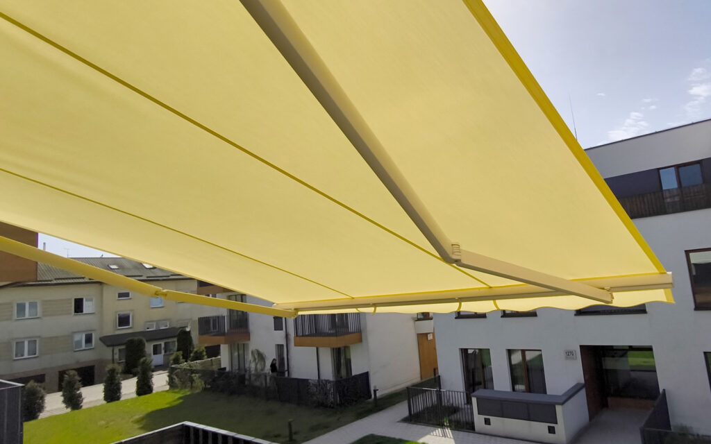 Markiza tarasowa Solaro z aluminiowymi ramionami zamontowana na tarasie domu jednorodzinnego