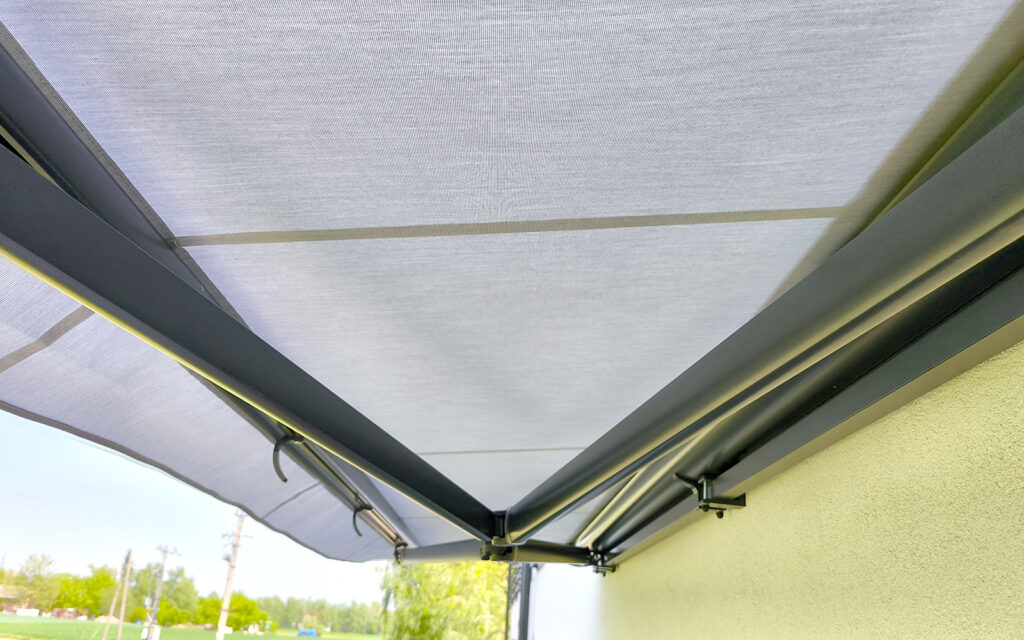 Markiza tarasowa Solaro z aluminiowymi ramionami zamontowana na tarasie domu jednorodzinnego