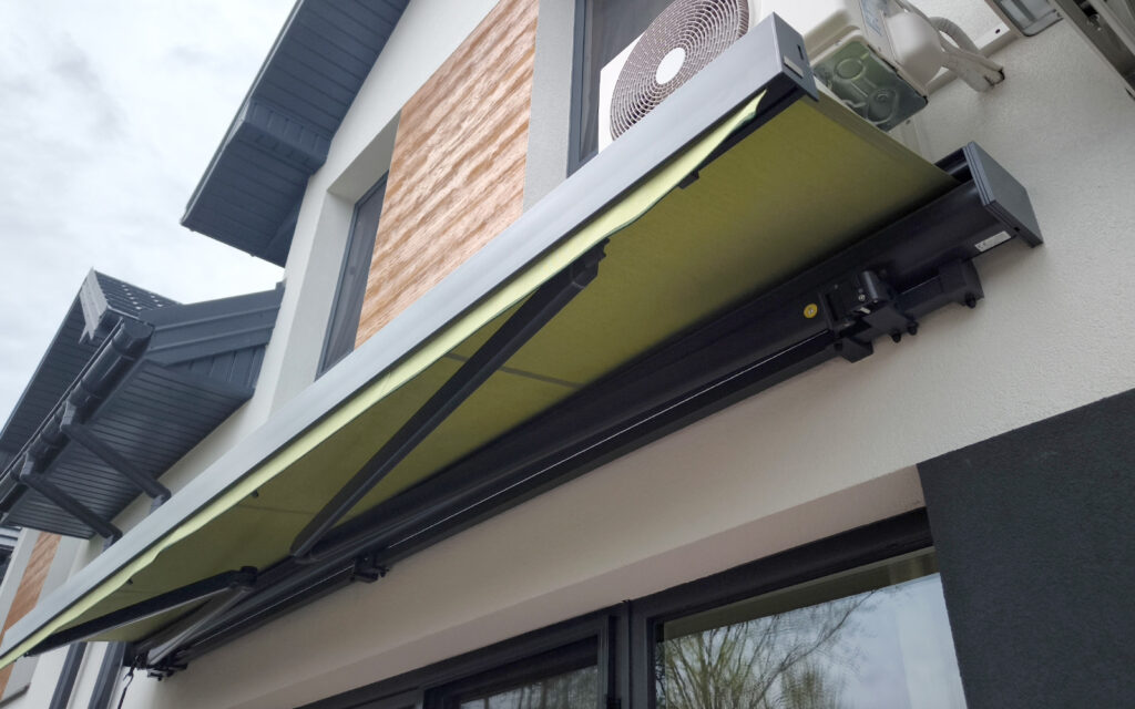 Markiza tarasowa Solaro z aluminiowymi ramionami zamontowana na tarasie domu jednorodzinnego