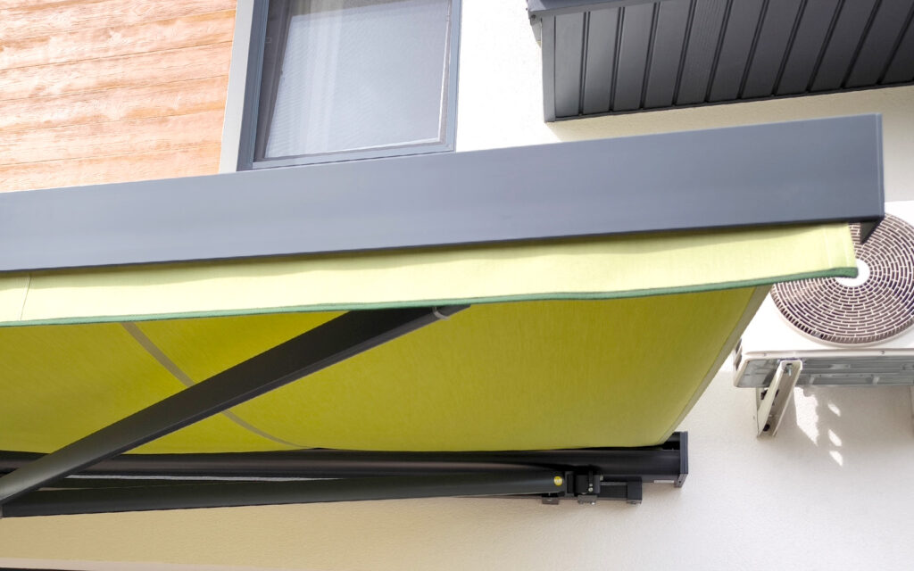 Markiza tarasowa Solaro z aluminiowymi ramionami zamontowana na tarasie domu jednorodzinnego